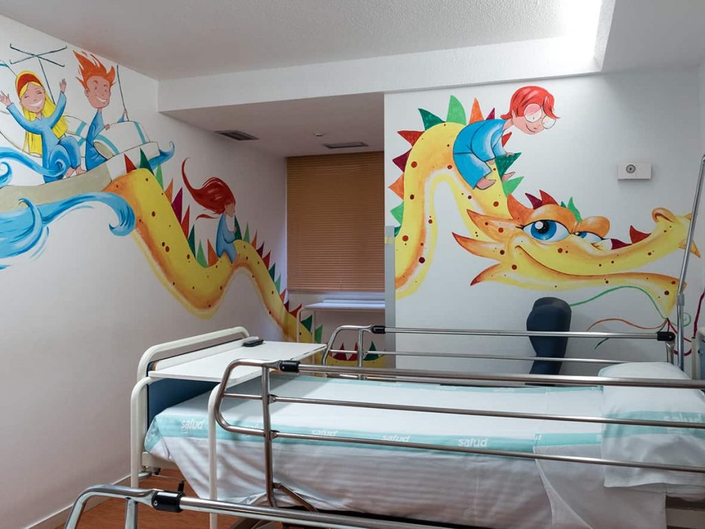 Habitación del Hospital Miguel Servet de Zaragoza que tiene pintado un dragón amarillo con unos niños montados sobre él